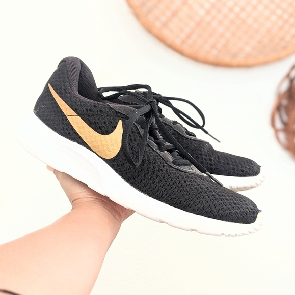 black nike shoes with gold swoosh